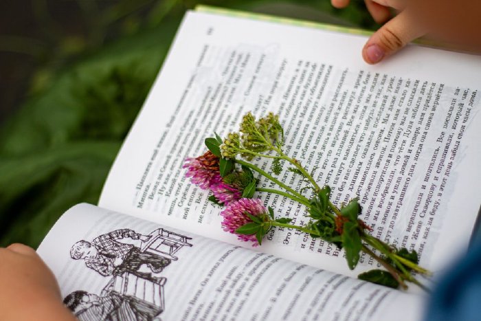 Дете чете книга, държейки я много близо до лицето си